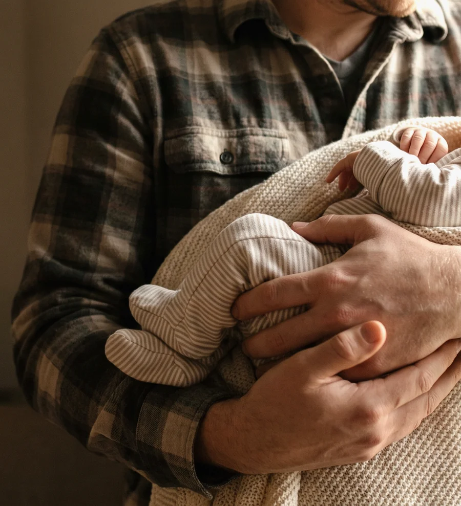 A father holding a newborn, the relationship an Illinois parentage case establishes