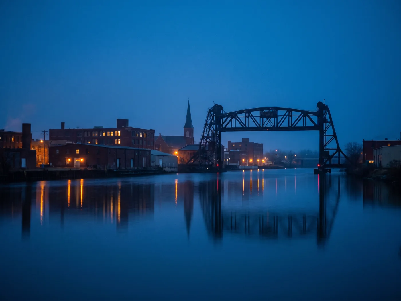 The river and steel lift bridge running through Joliet, Illinois, at dusk